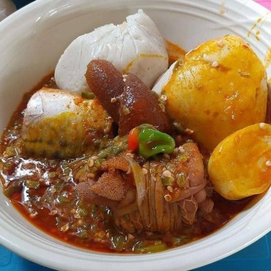 A plate of African food with jollof rice, plantain and grilled meat