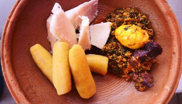 A plate of African food with jollof rice, plantain and grilled meat